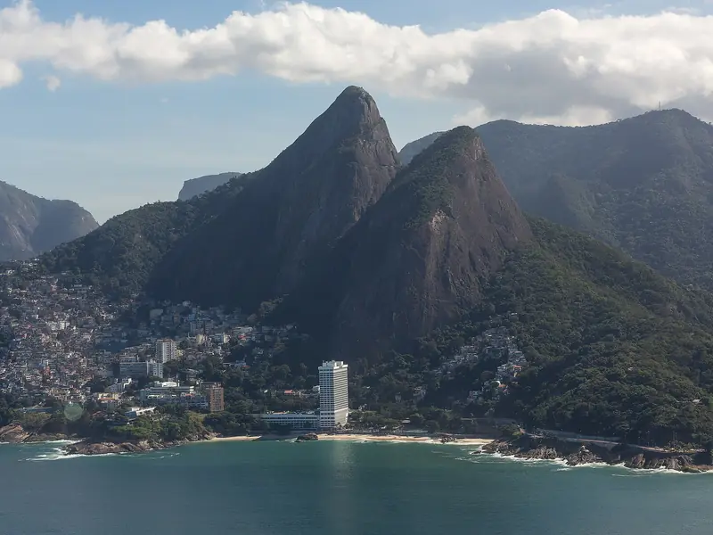 O Morro Dois Irmãos, com duas pontas de rocha cobertas de mata, acima da praia e do bairro do Vidigal.